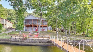A house with a balcony, a dock, and a small bridge over a body of water. - Water-view Deck! Family Home on Lake of the Ozarks (Roach)