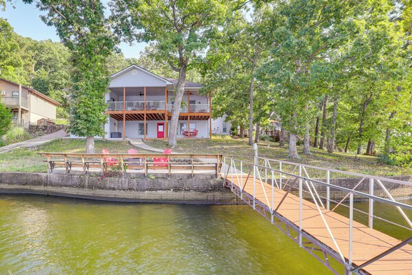 Una casa con un balcone, un molo e un piccolo ponte su un corso d'acqua.