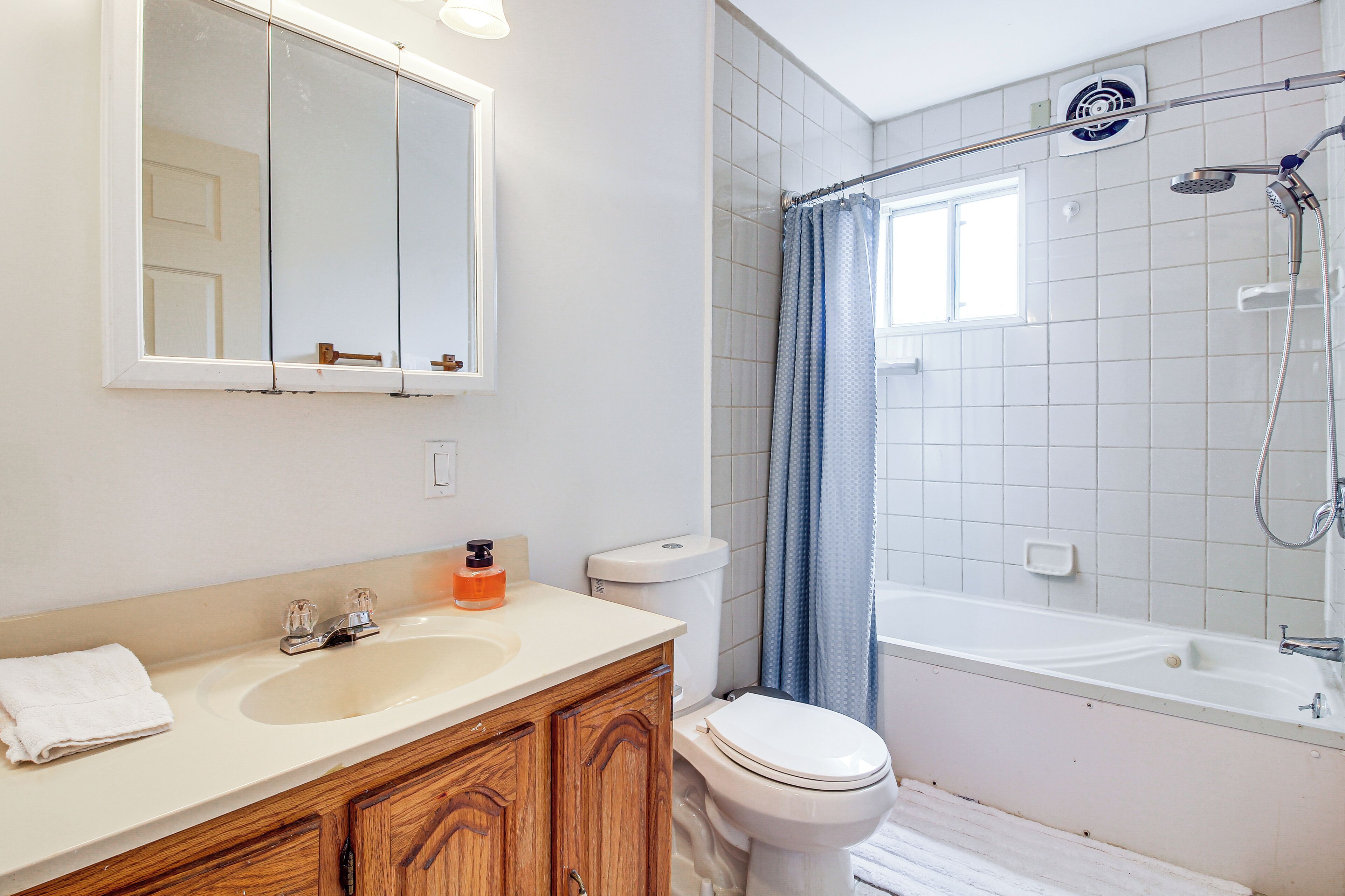 Une salle de bain moderne équipée d’un lavabo, d’un miroir, de toilettes et d’une baignoire.