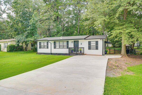 A single-story mobile home with a front porch, a driveway, and a well-maintained lawn.