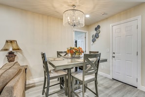 A dining area with a chandelier, a vase of flowers, and a white door.