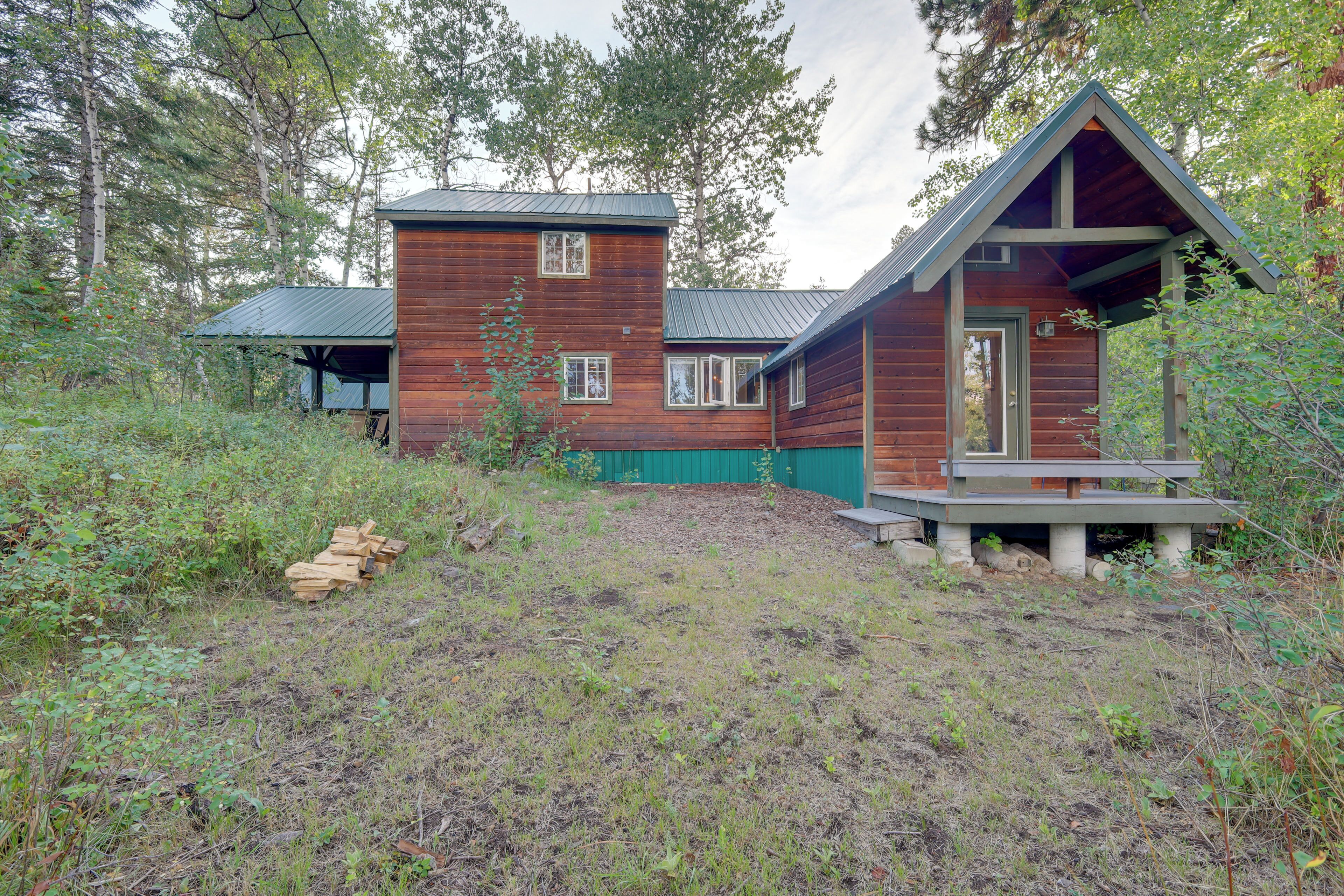A rustic cabin with a wooden exterior, a covered porch, and a small deck.
