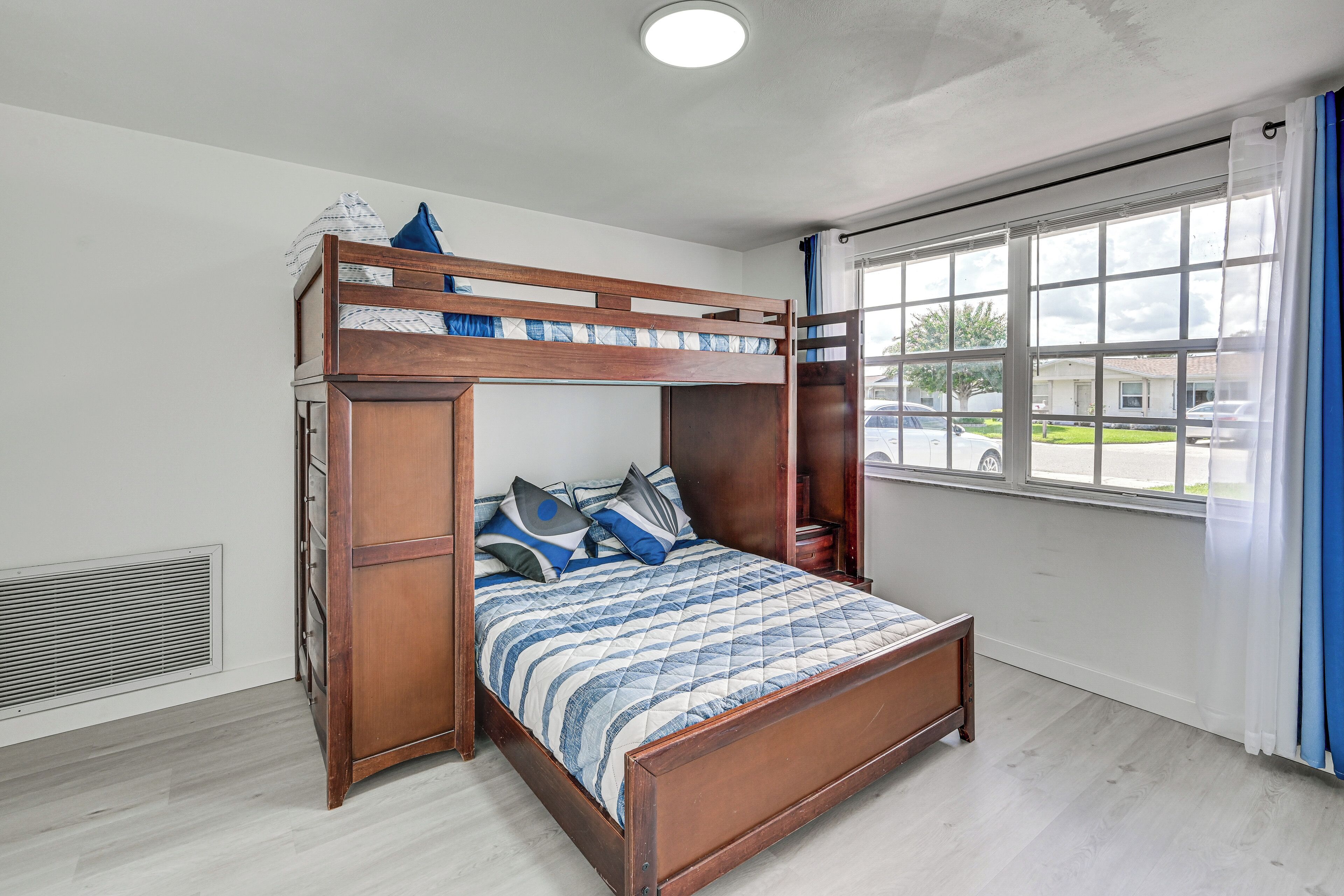A bunk bed with a wooden frame and a quilted bedspread.