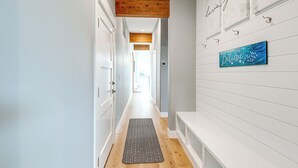 A hallway with a wooden ceiling, white walls, and a blue artwork. - Fenced Yard, Water & Island Views: Anacortes Home! (Anacortes)