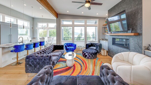 A modern kitchen with a bar area, a large window, and a ceiling fan. - Fenced Yard, Water & Island Views: Anacortes Home! (Anacortes)