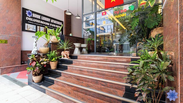 A hotel entrance with a sign for "Home Luxury Apartment" and a staircase leading to the entrance. - Studio in Modern building with AC; Kitchen; 1.3km from TSN airport (Hồ Chí Minh)