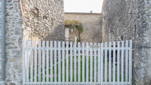 Una puerta de madera blanca con el número '52', ubicada entre muros de piedra.