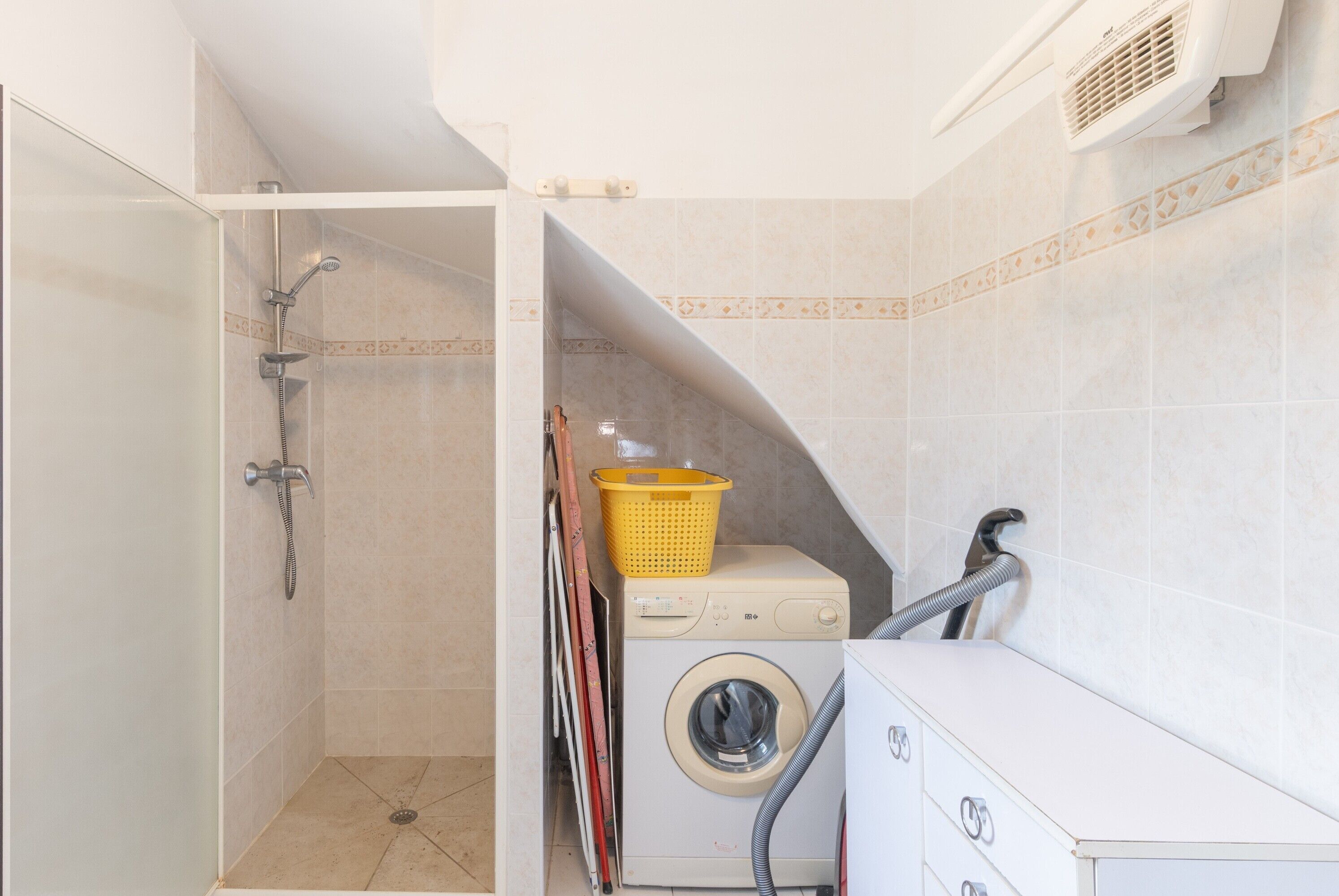 Un cuarto de lavandería con lavadora, secadora y ducha.