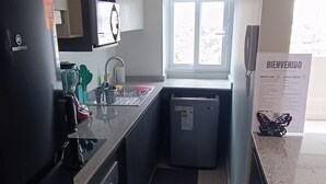 Une cuisine moderne équipée d’un réfrigérateur, d’une cuisinière, d’un évier et d’une fenêtre.