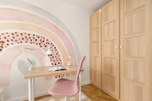 A study area with a desk, chair, and a large wardrobe.