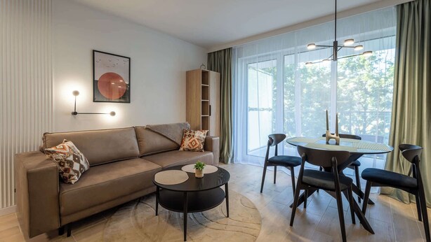 Un salon moderne avec un canapé, une table basse et une table à manger avec des chaises.