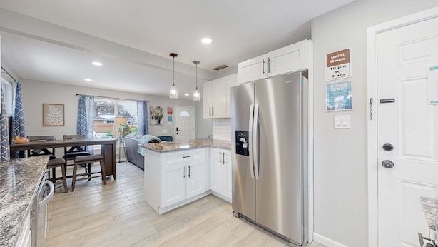 A modern kitchen with white cabinets, a stainless steel refrigerator, and a dining area with a table and chairs. There are signs indicating quiet hours and no smoking. - Affordable four bedroom Family Denver home (Denver)