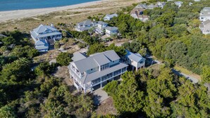 An aerial view of a coastal residential area with houses surrounded by dense greenery and a beach in the background. - Escape to Beacon Point Inn on Bald Head Island, NC-5 Bedrooms. Oceanview (Bald Head Island)