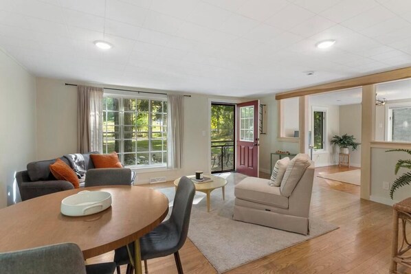 A spacious living room with a dining area, a sofa, and a small table.