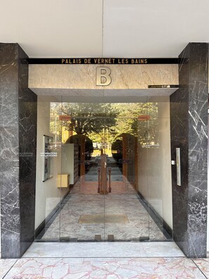 A hotel entrance with a marble facade, a glass door, and a sign reading 'PALAIS DE VERNET LES BAINS.' - Le Palais Apartment, ideal for spa treatments and hiking (Vernet-les-Bains)