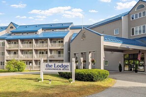Un edificio de dos pisos con un letrero que dice "The Lodge Condominium Hotel".