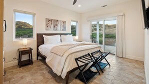 A bedroom with a bed, a nightstand, a ceiling fan, and a view of a landscape through the window. - Vineyard Views + Covered Patio | Paso Robles | Mission de los Robles (Paso Robles)