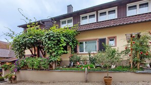 A house with a garden, a gravel driveway, and a wooden fence. - Apartment 'Weinbergblick' with Balcony and Wi-Fi (Auggen)