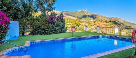 A swimming pool with a clear view of a mountain in the background.