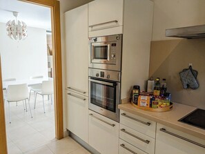 A modern kitchen with a microwave, oven, and a countertop with various items.