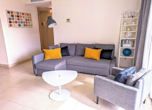 A living room with a grey sectional sofa, a white coffee table, and a grey armchair. - Amazing resort with several pools, gym, jacuzzi (Marbella)