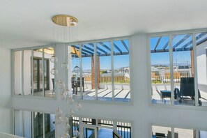 A room with large windows, a chandelier, and a view of the outside. - Luxury villa just 4 min walk to beach, heated pool (Mijas Costa)