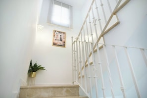 A staircase with white balusters and a beige carpeted landing.