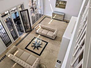 A spacious living area with a beige sofa set, a glass coffee table, and a patterned rug. - Luxury villa just 4 min walk to beach, heated pool (Mijas Costa)