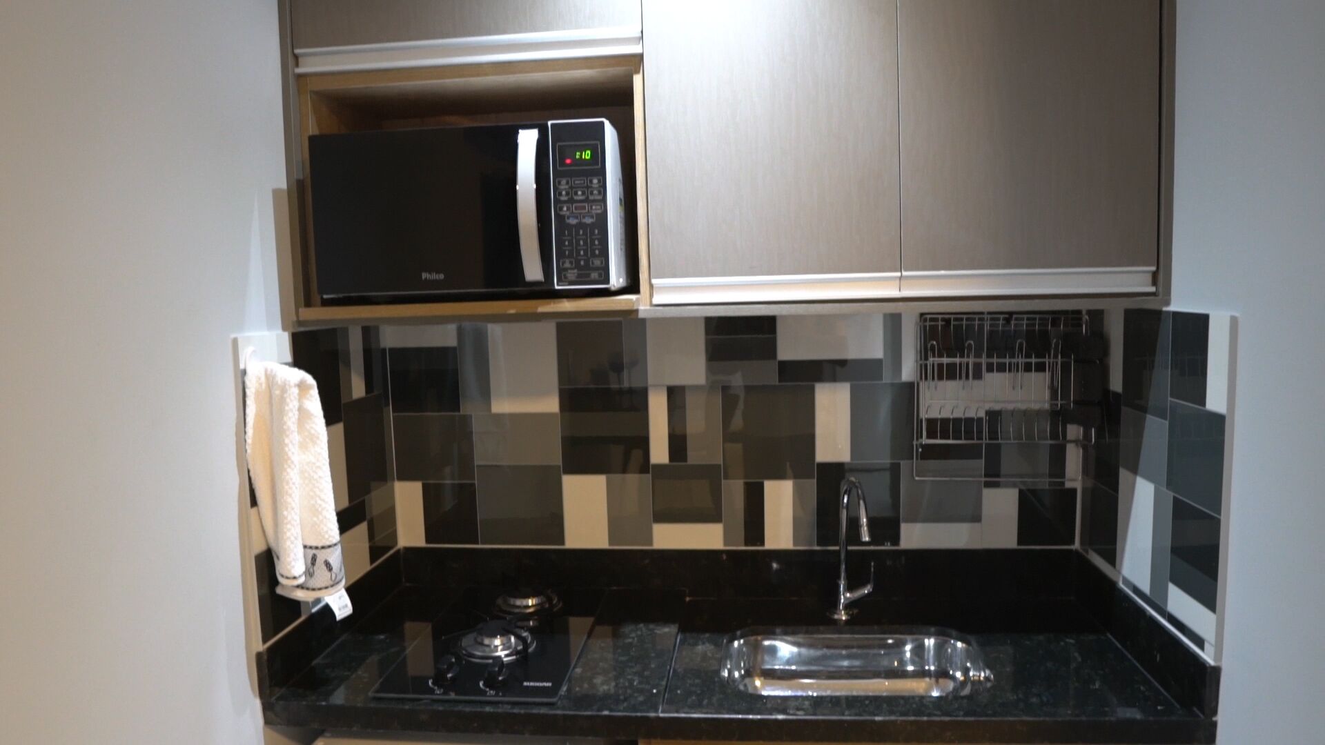A kitchen with a microwave, a stove, and a sink.