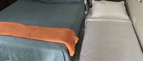 Una habitación con una cama, una mesita de noche y aire acondicionado de pared.