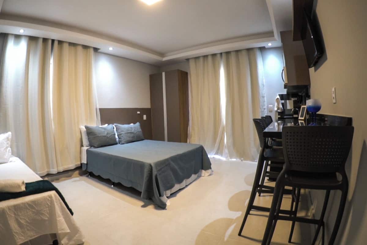 A hotel room with a bed, a desk, and a chair.