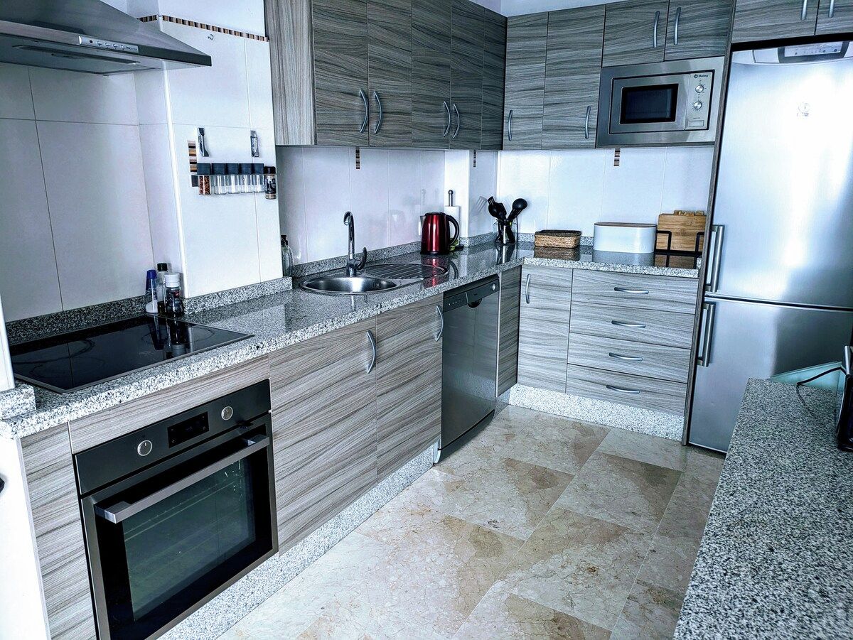 A modern kitchen with a built-in oven, microwave, and dishwasher.