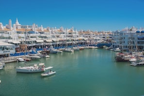 A marina with boats docked, surrounded by white buildings with blue accents. - Beautiful apartment - short walk to the beach (Benalmadena)