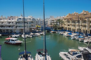 Un port de plaisance où sont amarrés de nombreux bateaux, entouré de bâtiments à l’architecture traditionnelle.