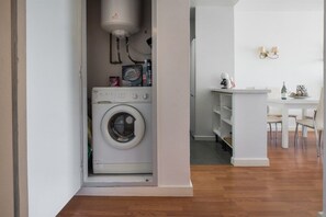 A laundry room with a washing machine, a water heater, and a small table with chairs. - Fantastic seaviews & pool, close to the beach (Benalmadena)
