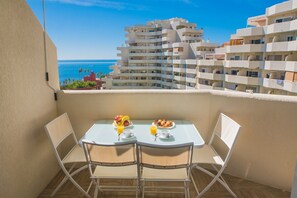 A balcony with a table set for breakfast, overlooking a coastal cityscape. - Fantastic seaviews & pool, close to the beach (Benalmadena)