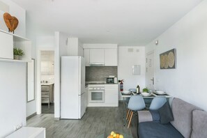 A modern kitchen with white cabinets, a built-in oven, and a microwave.