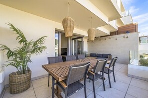 An outdoor dining area with a wooden table and chairs, two hanging wicker lamps, and a potted plant. - Panoramic views & great location - walk to beach! (La Cala de Mijas)