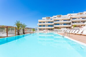 A swimming pool with lounge chairs and a building with multiple balconies in the background. - Panoramic views & great location - walk to beach! (La Cala de Mijas)