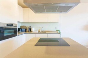 A modern kitchen with a built-in oven, a coffee maker, and a sink. - Luxury living with sea views. Walk to the beach (La Cala de Mijas)