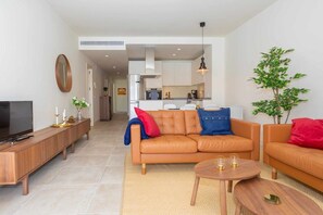A modern living room with a sofa, coffee table, and TV stand. - Walk to Beach! Premium apartment pool & gym (La Cala de Mijas)