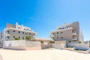 A modern building with a symmetrical facade, multiple balconies, and a gated entrance. - Modern 3 bedroom apartment, very close to beach (La Cala de Mijas)