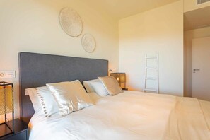 A neatly made bed with pillows, a bedside lamp, and wall art. - Amazing seaview near the beach! (La Cala de Mijas)