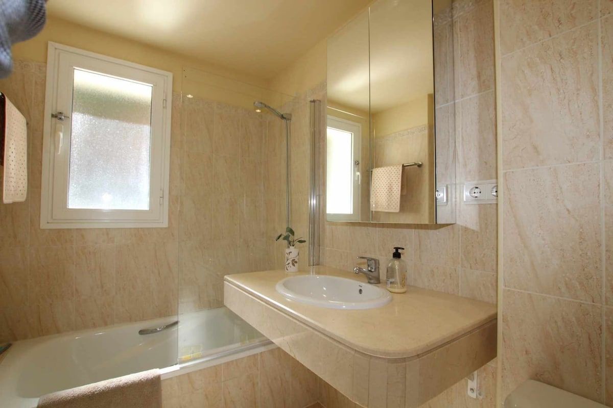 A bathroom with a bathtub, a sink, a mirror, and a shower.