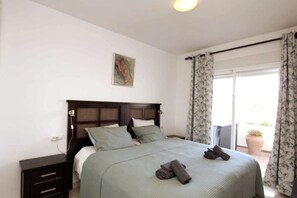 A bedroom with a bed, a nightstand, a painting, and a view of the outdoors. - Spacious, bright penthouse 3 terraces & sea view (Calahonda)
