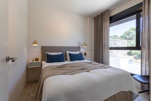 A bedroom with a bed, bedside lamps, a nightstand, and a window with curtains. - Seaviews & pool close to beach (La Cala de Mijas)