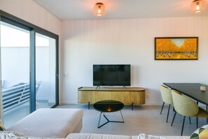 A modern hotel room with a large bed, a TV, a dining table with chairs, and a painting on the wall. - Premium penthouse with sea views (La Cala de Mijas)
