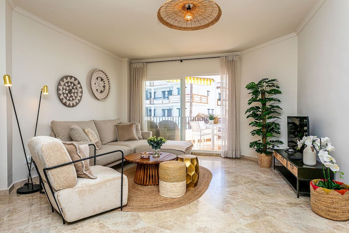 Un salon comprenant un canapé, un fauteuil, une table basse et des objets de décoration.