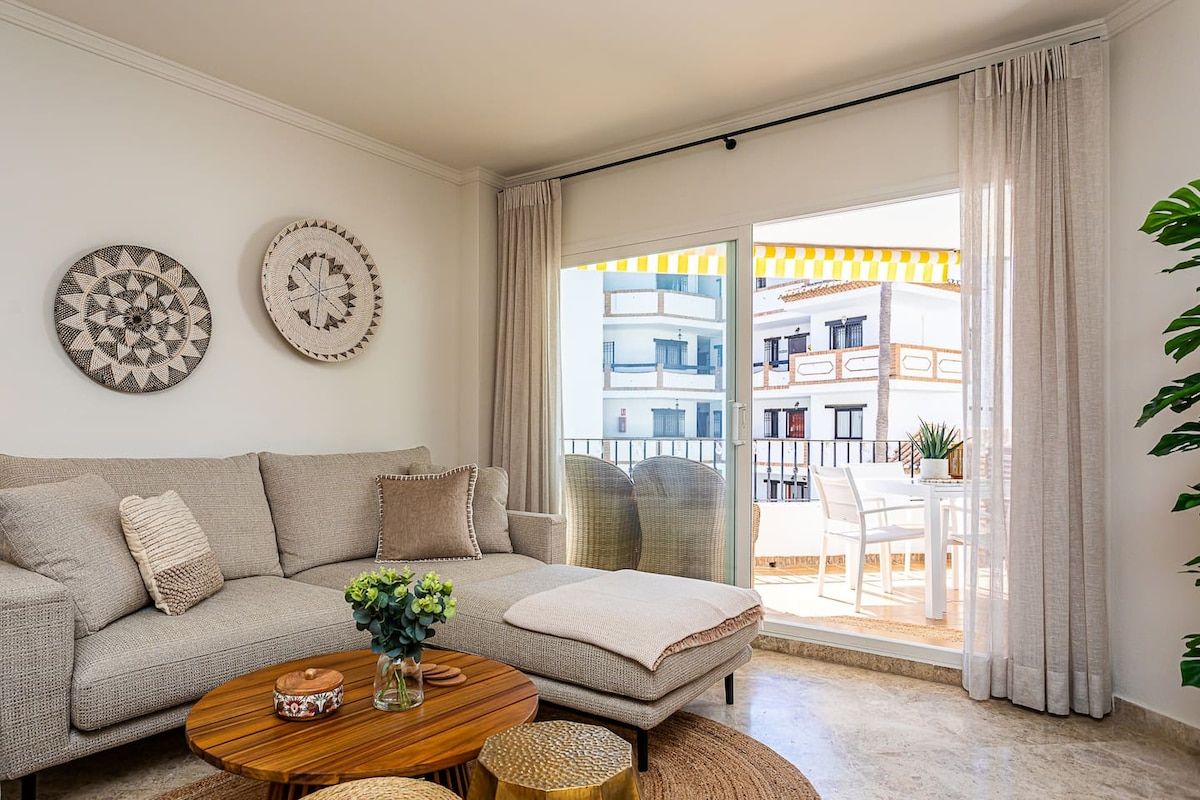 Un salon avec un canapé, une table basse et des assiettes décoratives accrochées au mur.