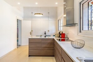 Eine moderne Küche mit einer zentralen Kochinsel, eingebauten Schränken und einem Fenster für natürliches Licht.